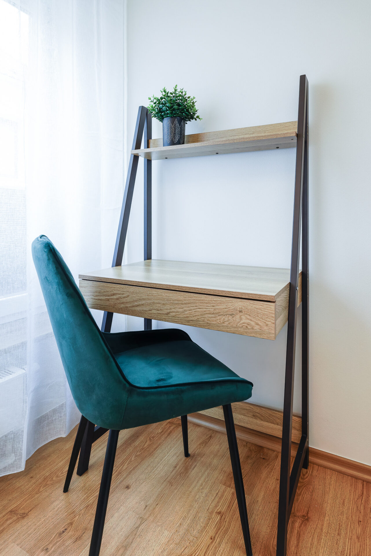 Minimalist workspace with green velvet chair at Kuressaare Stays apartment in Saaremaa